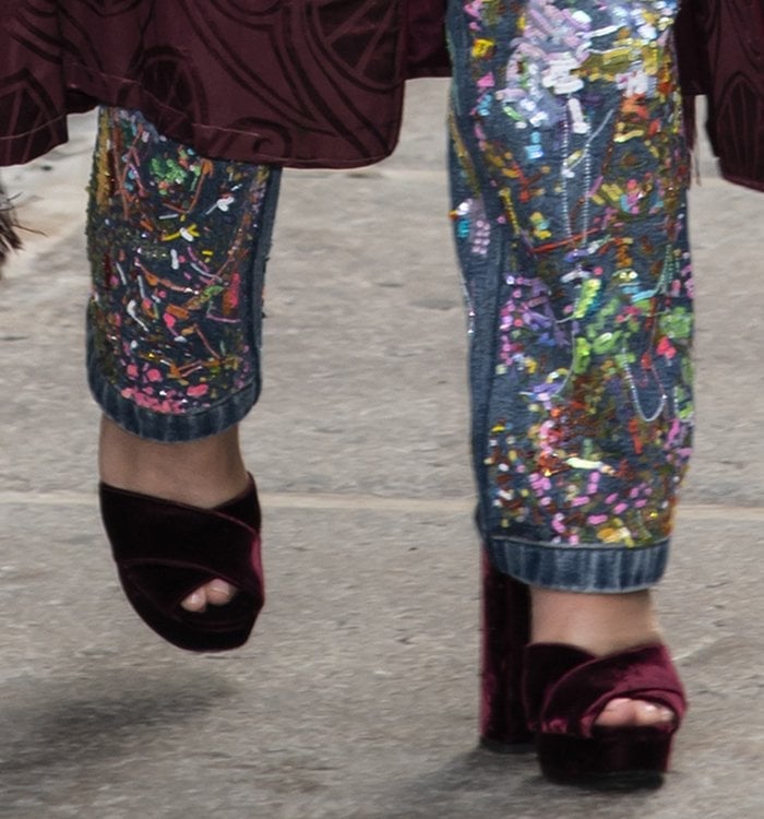 Chrissy Teigen keeps the look coordinated with Prada burgundy velvet platform heels