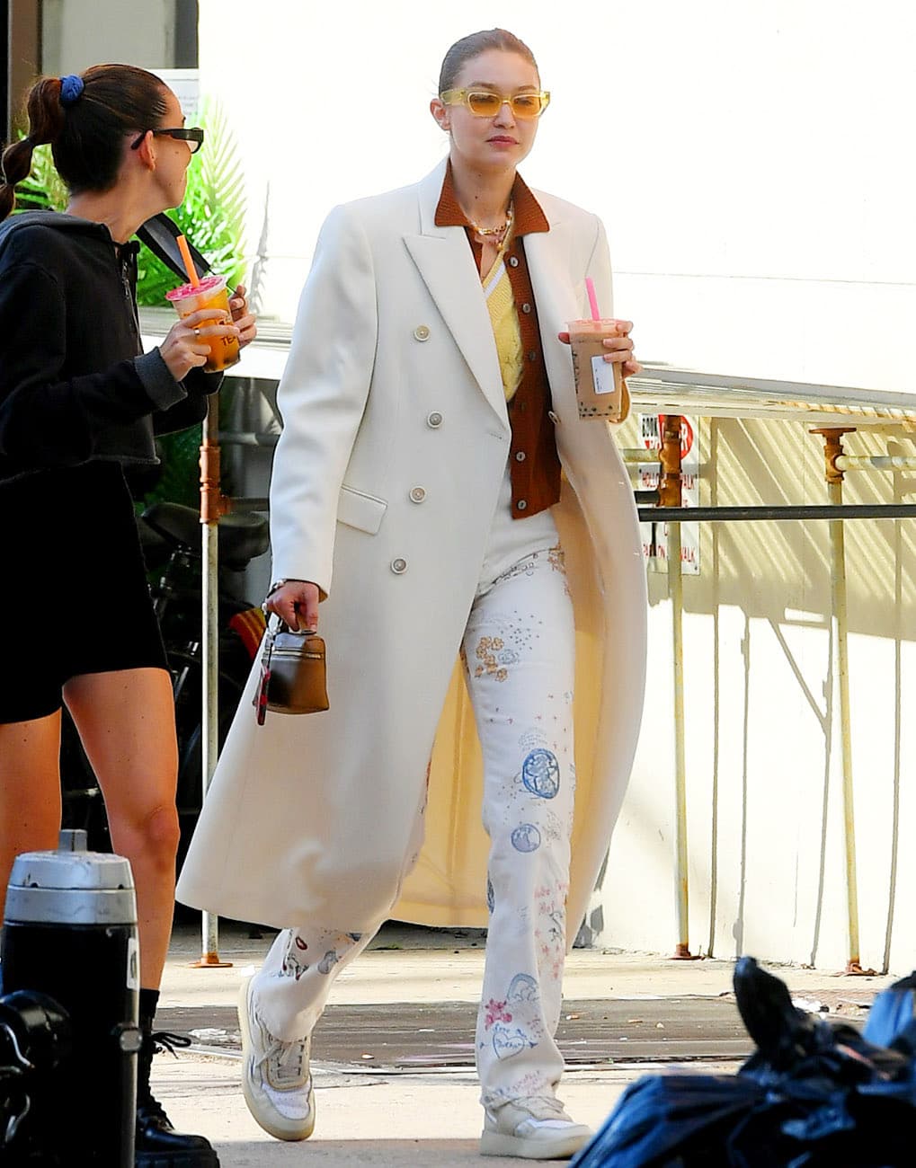 Gigi Hadid shows how to wear a retro fall look with a Wardrobe.NYC white coat, Public Habit rust cardigan, and Reformation white doodle pants