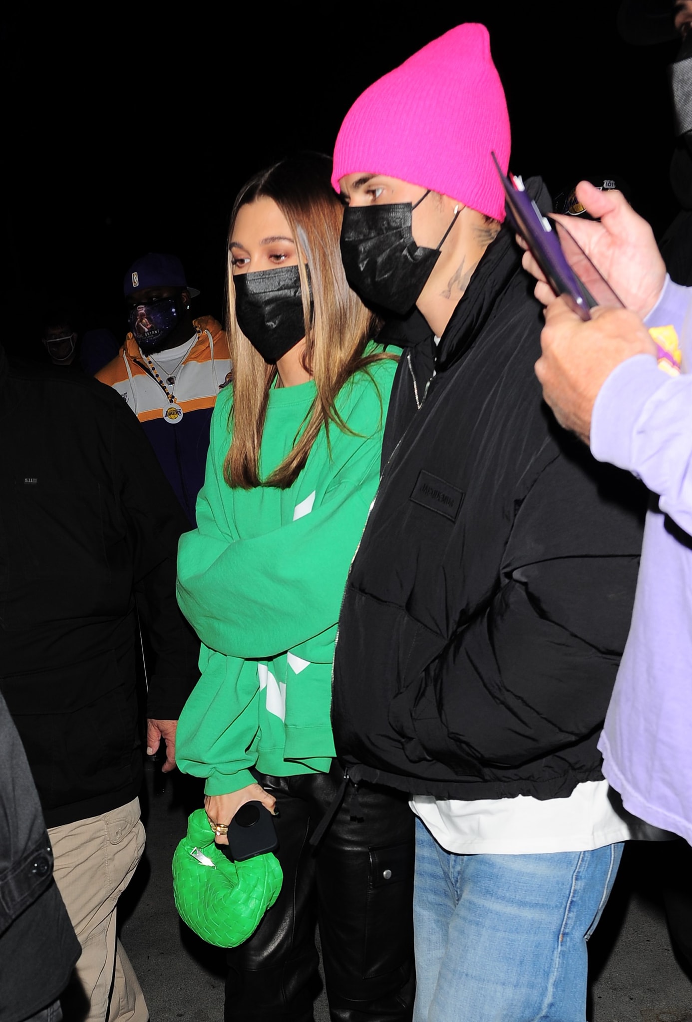 Hailey Bieber hides her face behind a face mask and carries a Bottega Veneta mini Jodie bag