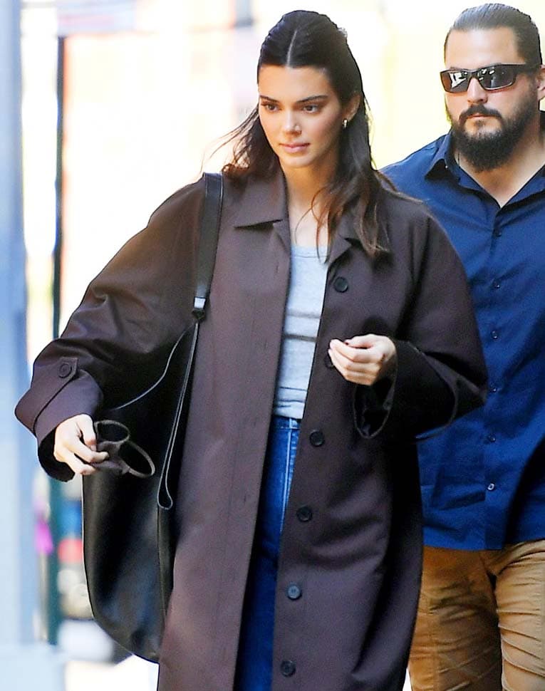 Kendall Jenner wears barely-there makeup and pulls her hair back into a center-parted half-up style