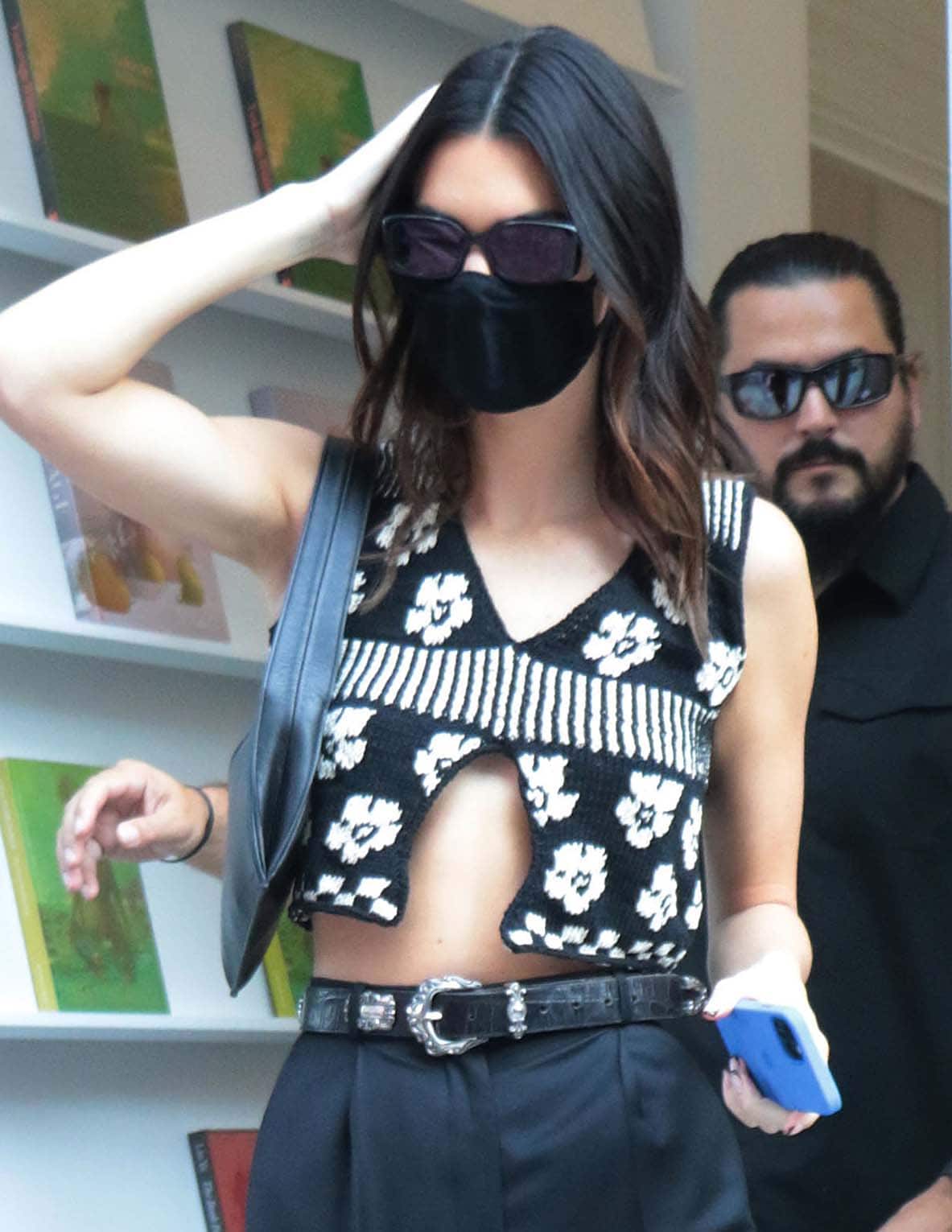 Kendall Jenner wears her brunette tresses down and covers her face with black rectangular sunglasses and a face mask