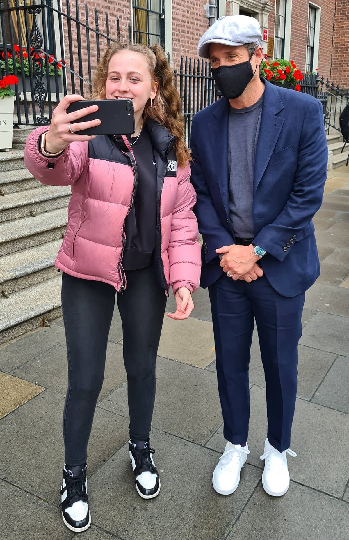 A fully masked Patrick Dempsey with a fan outside The Merrion Hotel in the heart of Dublin city center on August 5, 2021, after wrapping up filming for the Disenchanted movie in Ireland