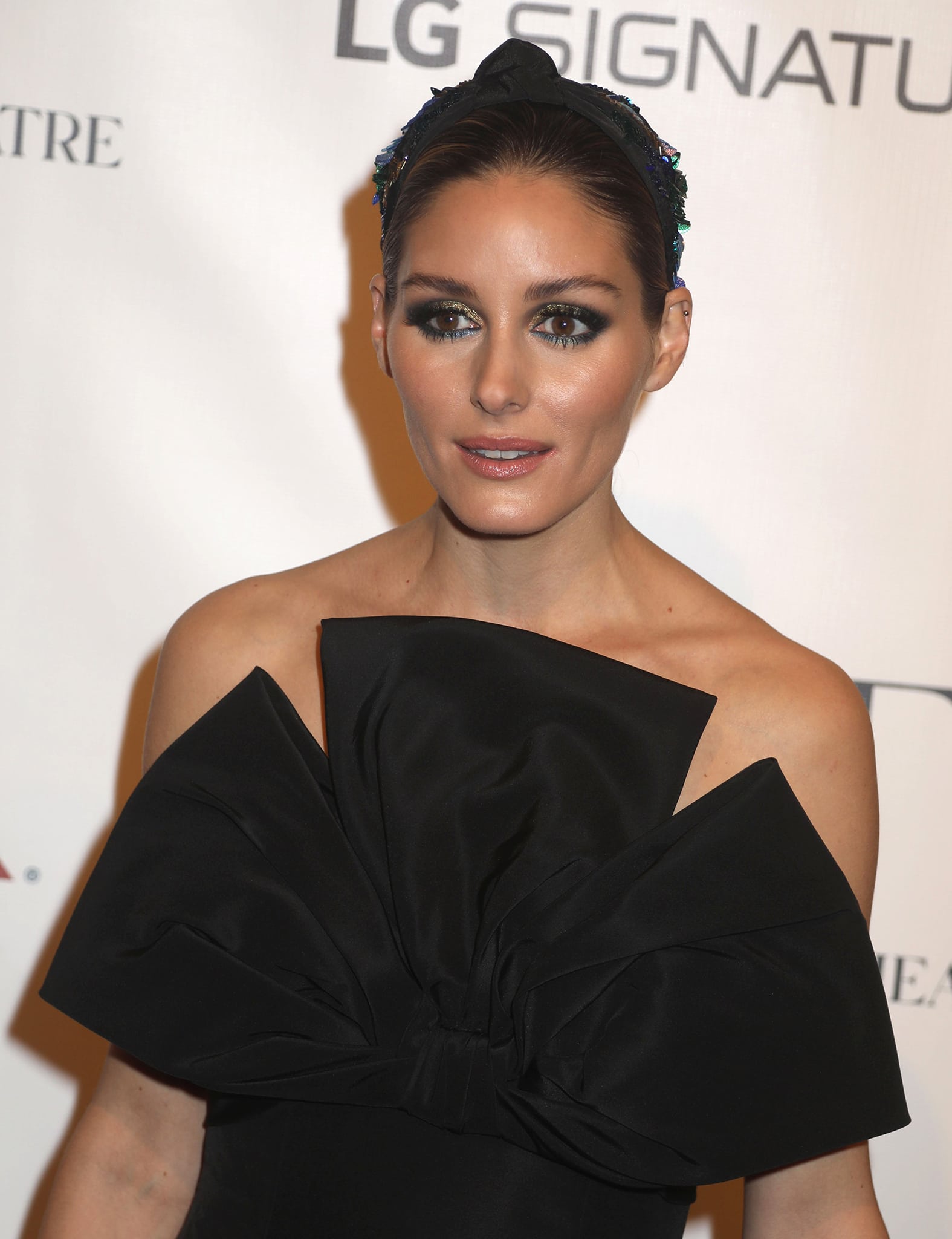 Olivia Palermo wears shimmering smokey eye-makeup with perfectly coiffed hair and an embellished Meredith Hope headband