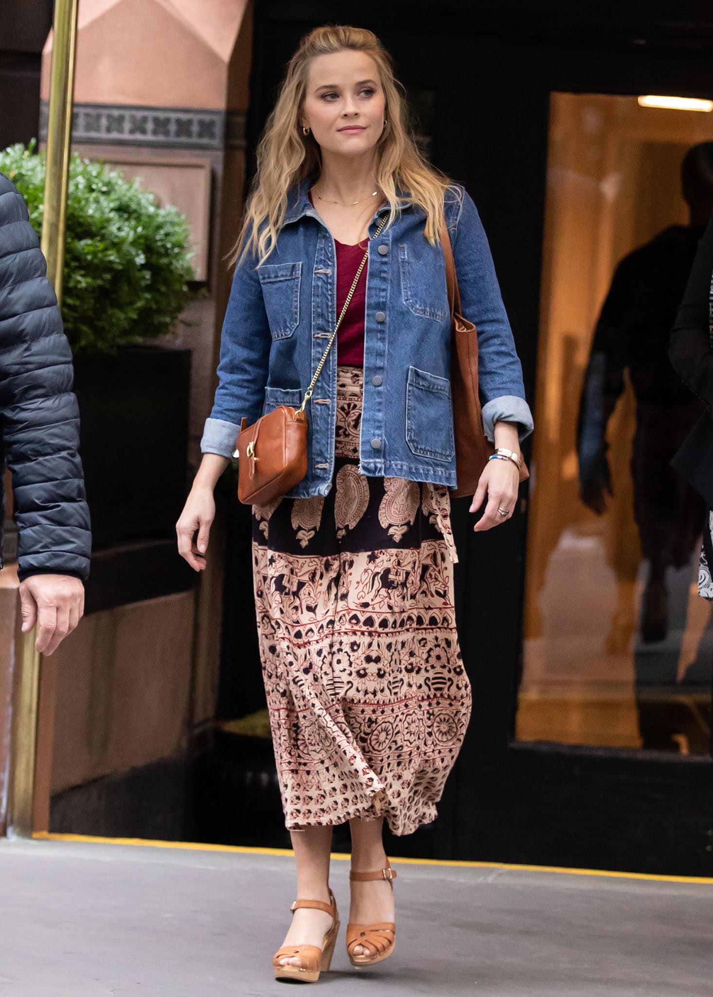 Reese Witherspoon opts for an autumnal look in a printed maxi skirt and burgundy tee