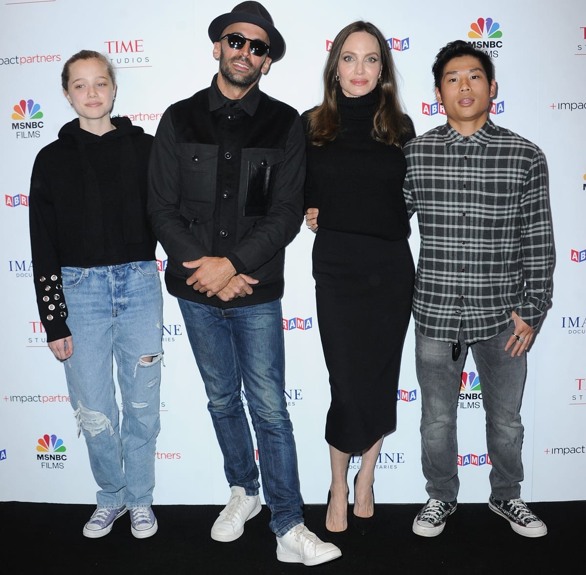 Shiloh Jolie-Pitt in ripped jeans with street artist JR, Angelina Jolie, and Pax Thien Jolie-Pitt at the Los Angeles premiere of MSNBC Films' "Paper & Glue: A JR Project"