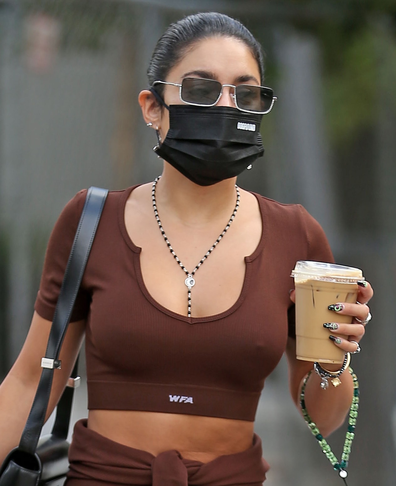 Vanessa Hudgens wears a sleek bun and hides her eyes behind Miu Miu crystal-embellished sunglasses