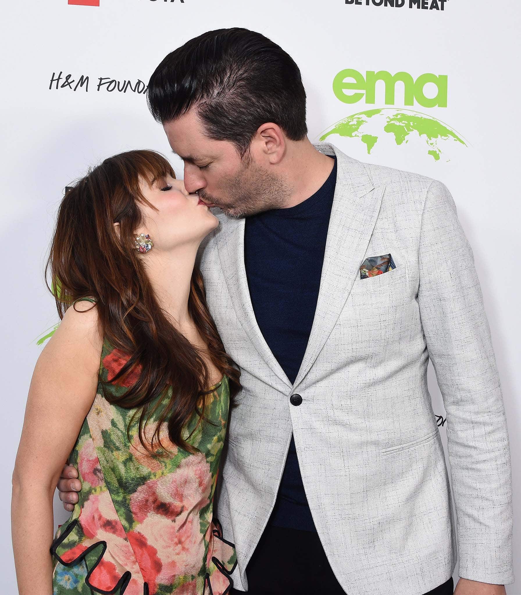 Zooey Deschanel and Jonathan Scott share a kiss on the green carpet