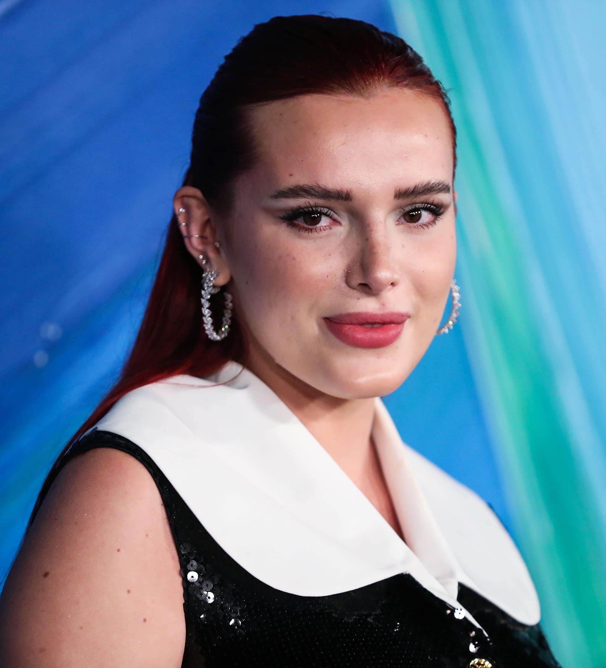 Bella Thorne scrapes her red tresses back into a ponytail and wears winged eyeliner with pink lipstick