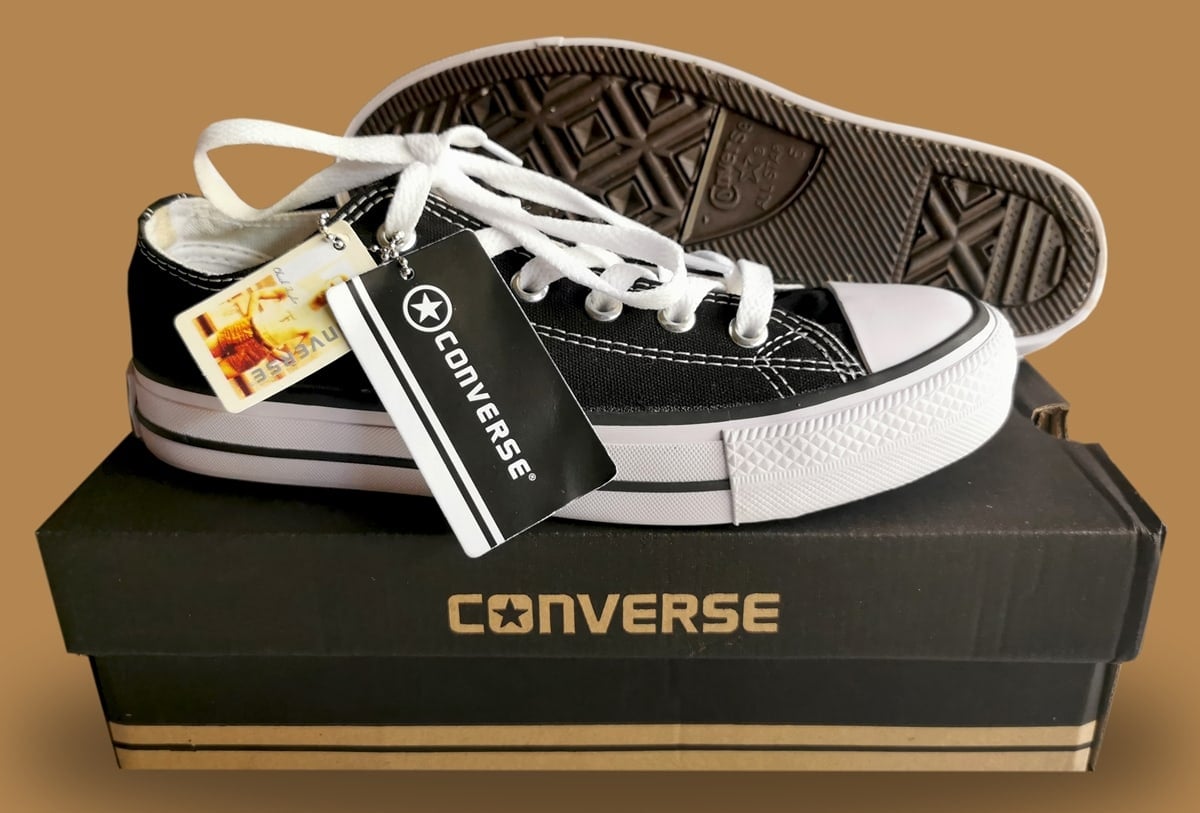Black Chuck Taylor All Star low-top sneaker with a retail box featuring the Converse logo