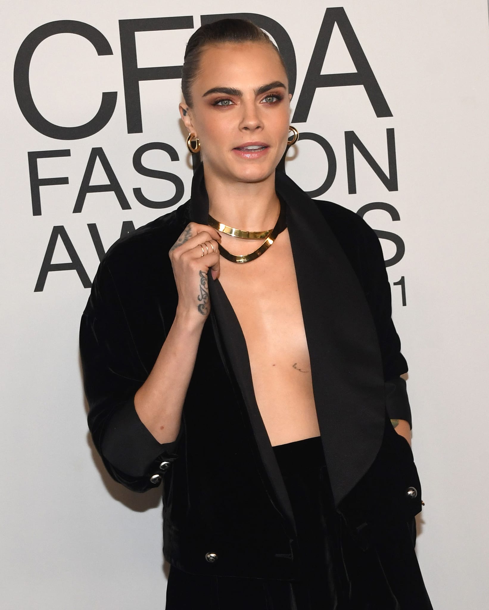 Cara Delevingne wears a neat bun with smokey eye-makeup and nude lipstick