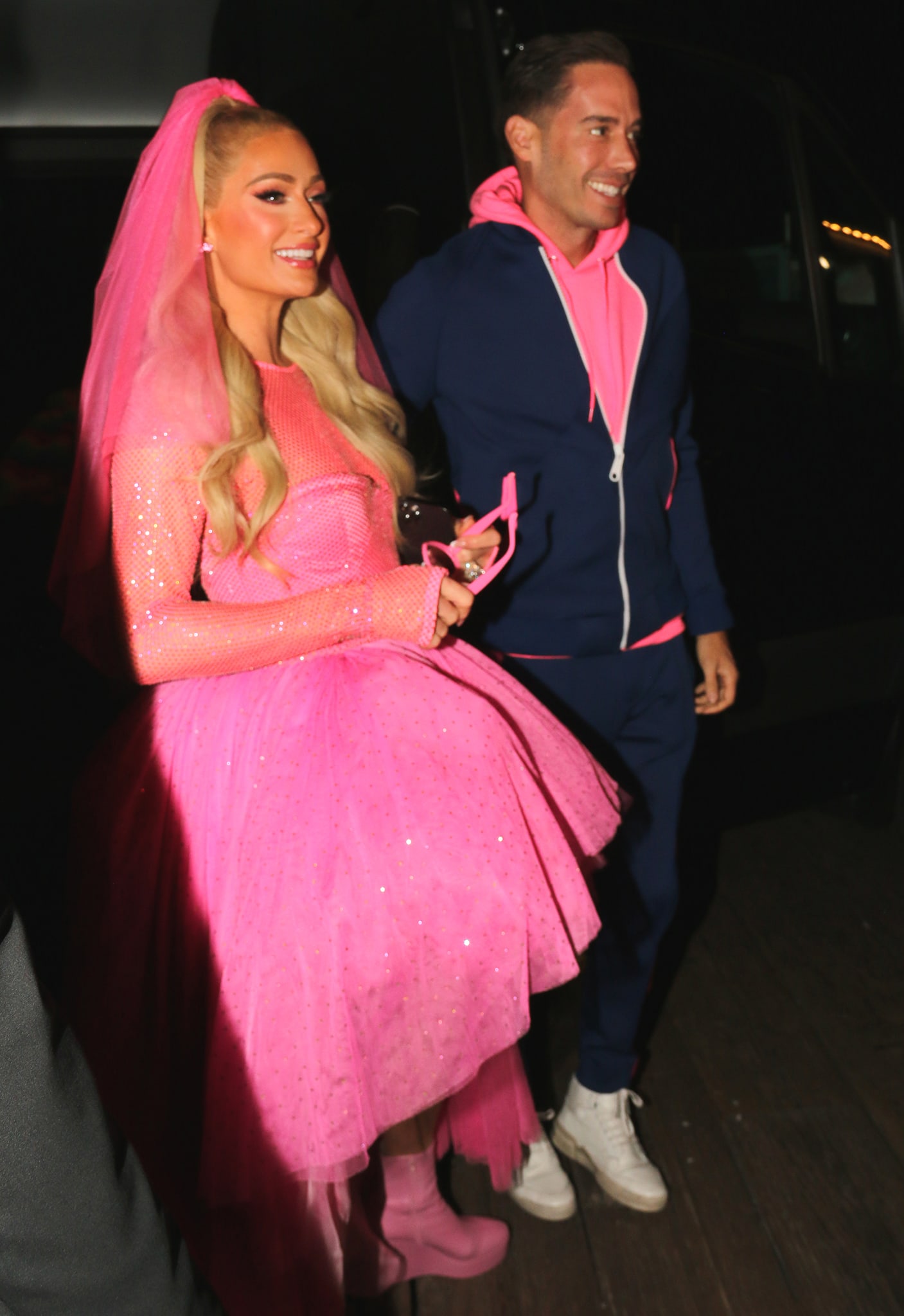 Paris Hilton's husband Carter Reum coordinates her look in a pink hoodie with navy and pink tracksuit