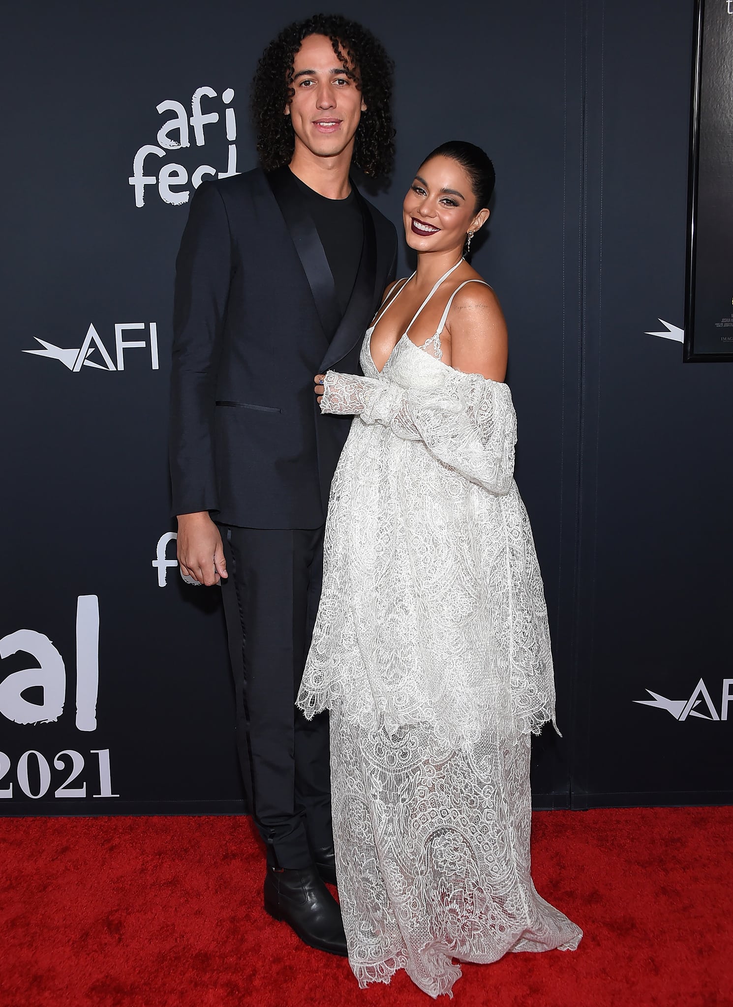 Cole Tucker looks sharp in a black tuxedo while Vanessa channels her inner bohemian in a white lace Vera Wang dress