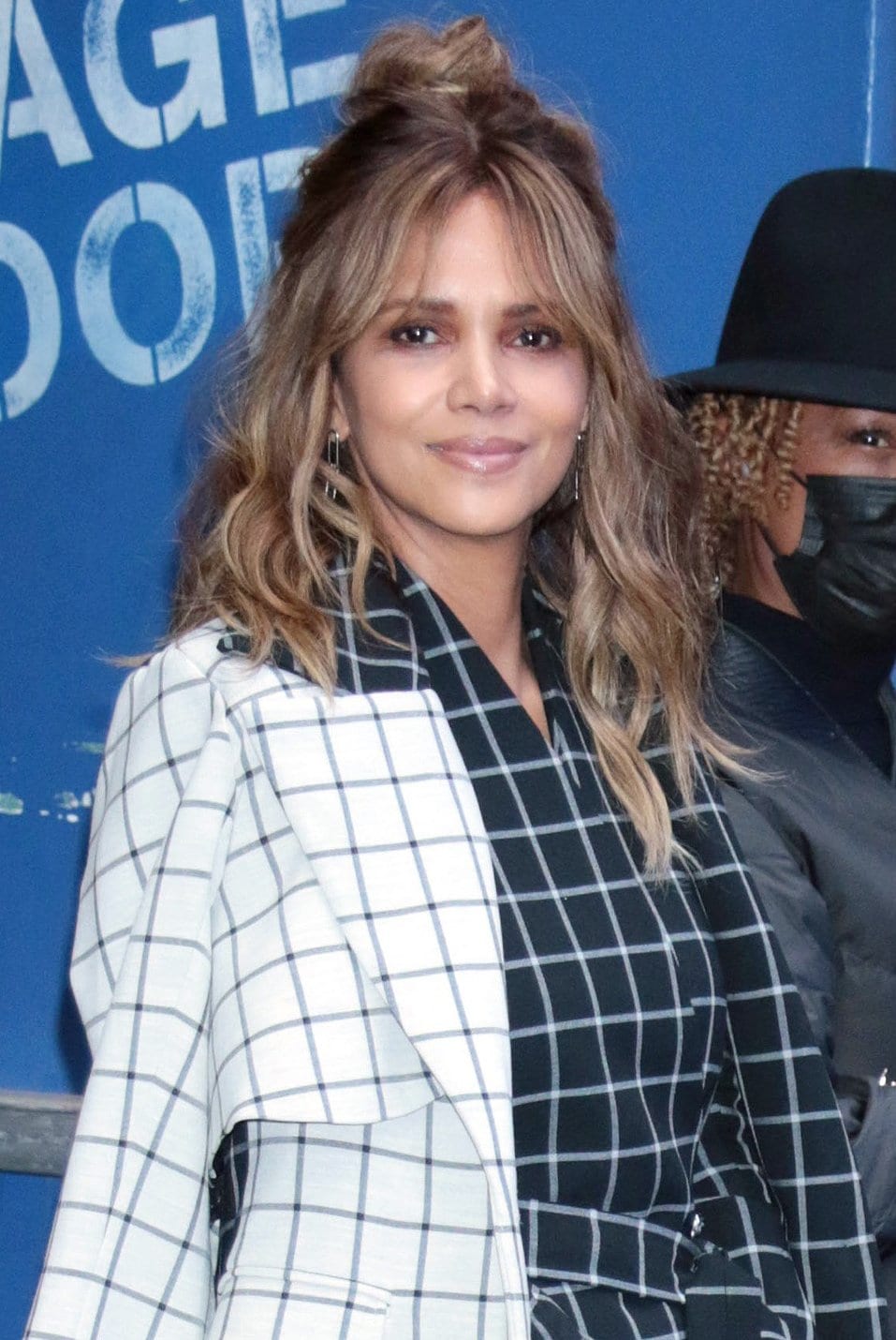 Halle Berry looks beautiful with minimal makeup and a half-up top-knot wavy hairstyle