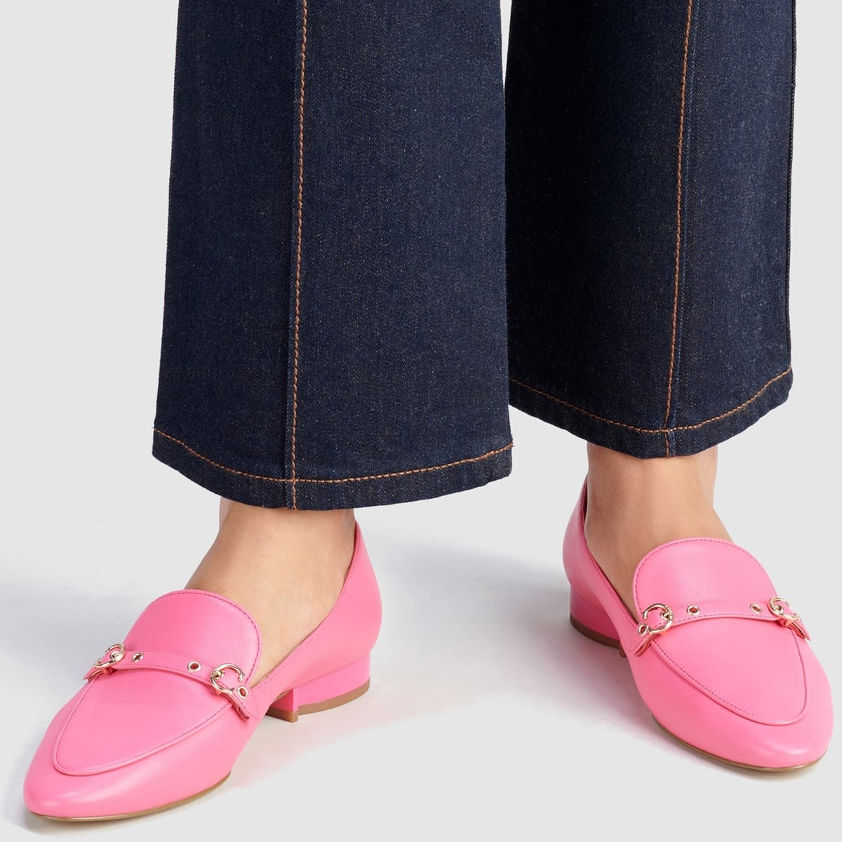 Polished buckles modeled after the Coach logo add a signature element to this bright watermelon suave, streamlined loafer