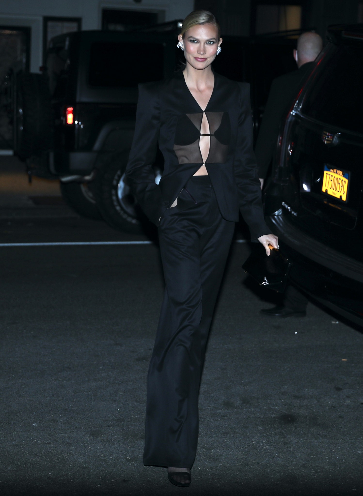 Karlie Kloss flashes her abs and cleavage in Grace Ling sheer-paneled blazer, bralette, and high-waist pants