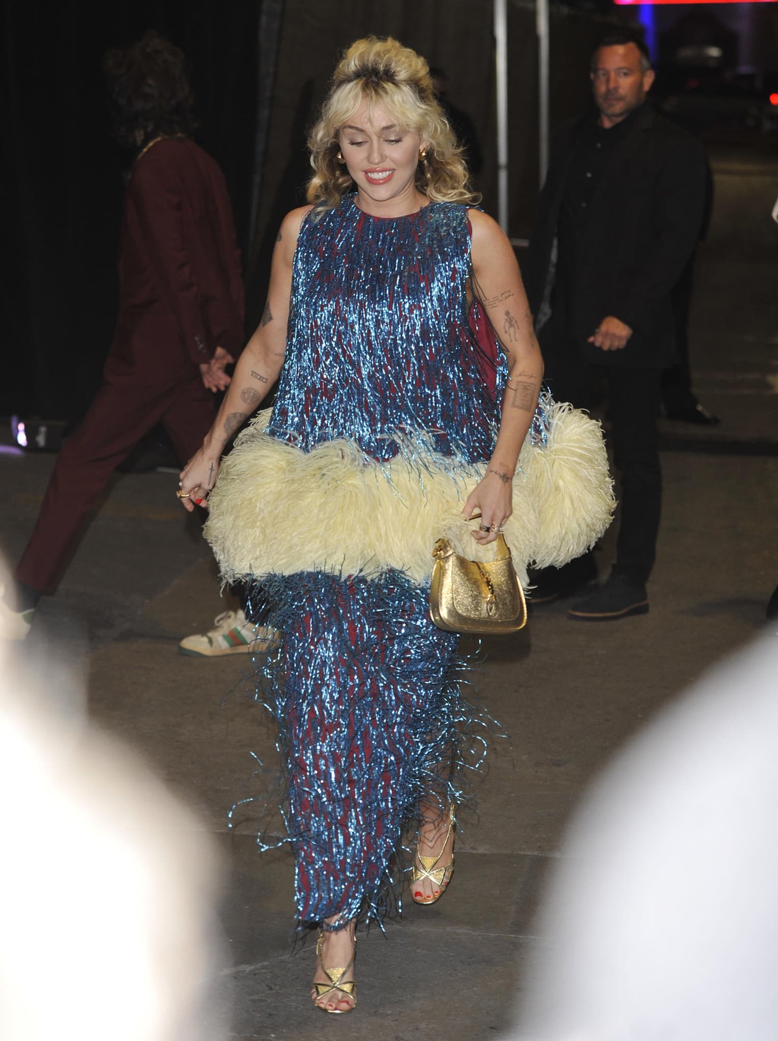 Miley Cyrus in a Gucci fringed dress with oversized feather trim at Gucci's Love Parade fashion show