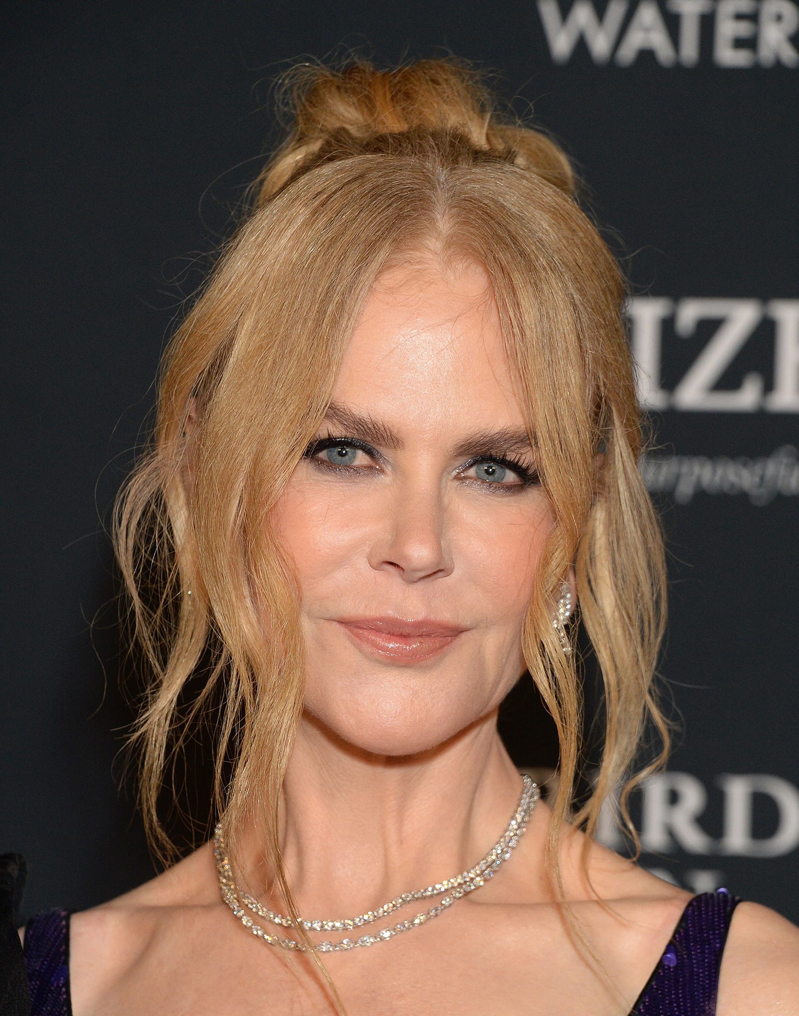 Nicole Kidman wears her red tresses up into a chic bun with loose tendrils framing her gorgeously made-up face