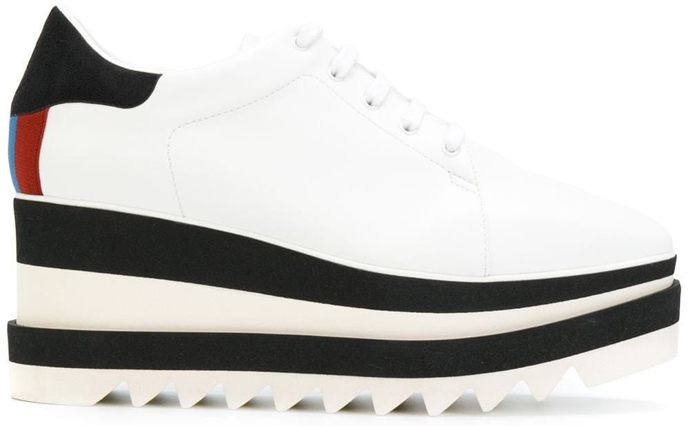 Stella McCartney's signature platform sneakers are made of fake white leather and feature black block stripes along the platforms