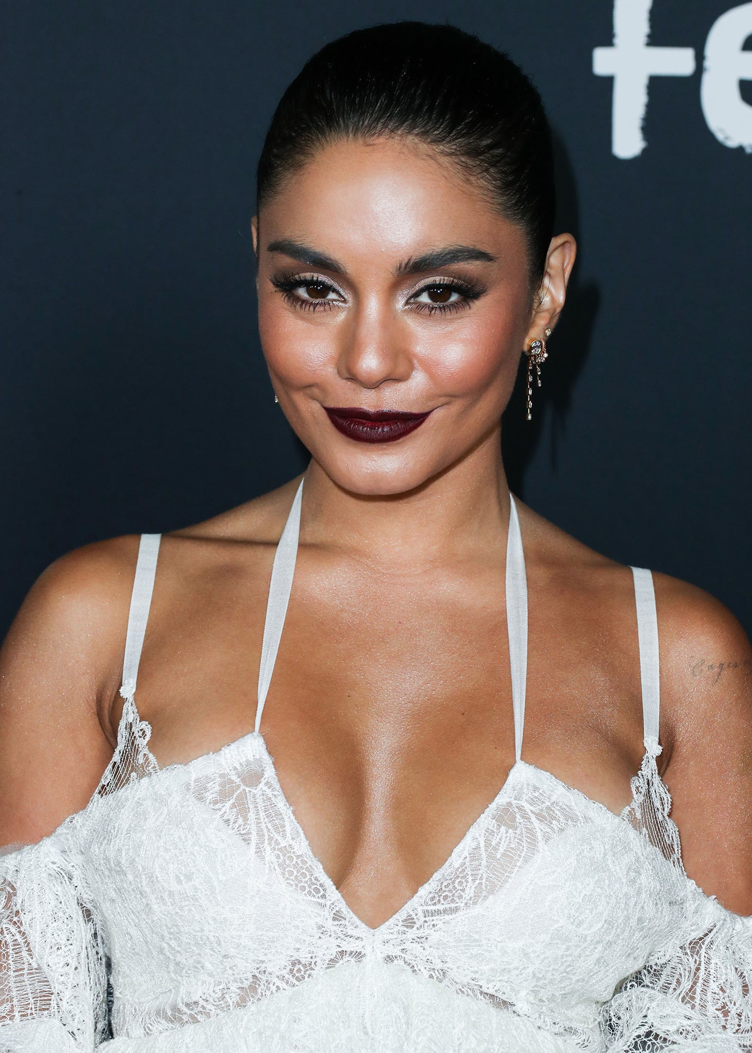 Vanessa Hudgens glams up with smokey eyeshadow, plum lip color, and braided ponytail