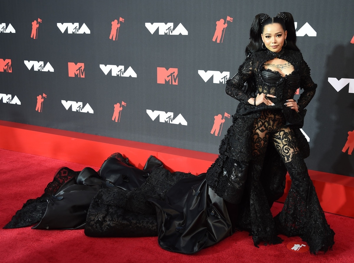 “Build a Bitch” singer Bella Poarch in a dramatic black lace jumpsuit featuring a cape and flared pants at the 2021 MTV Video Music Awards