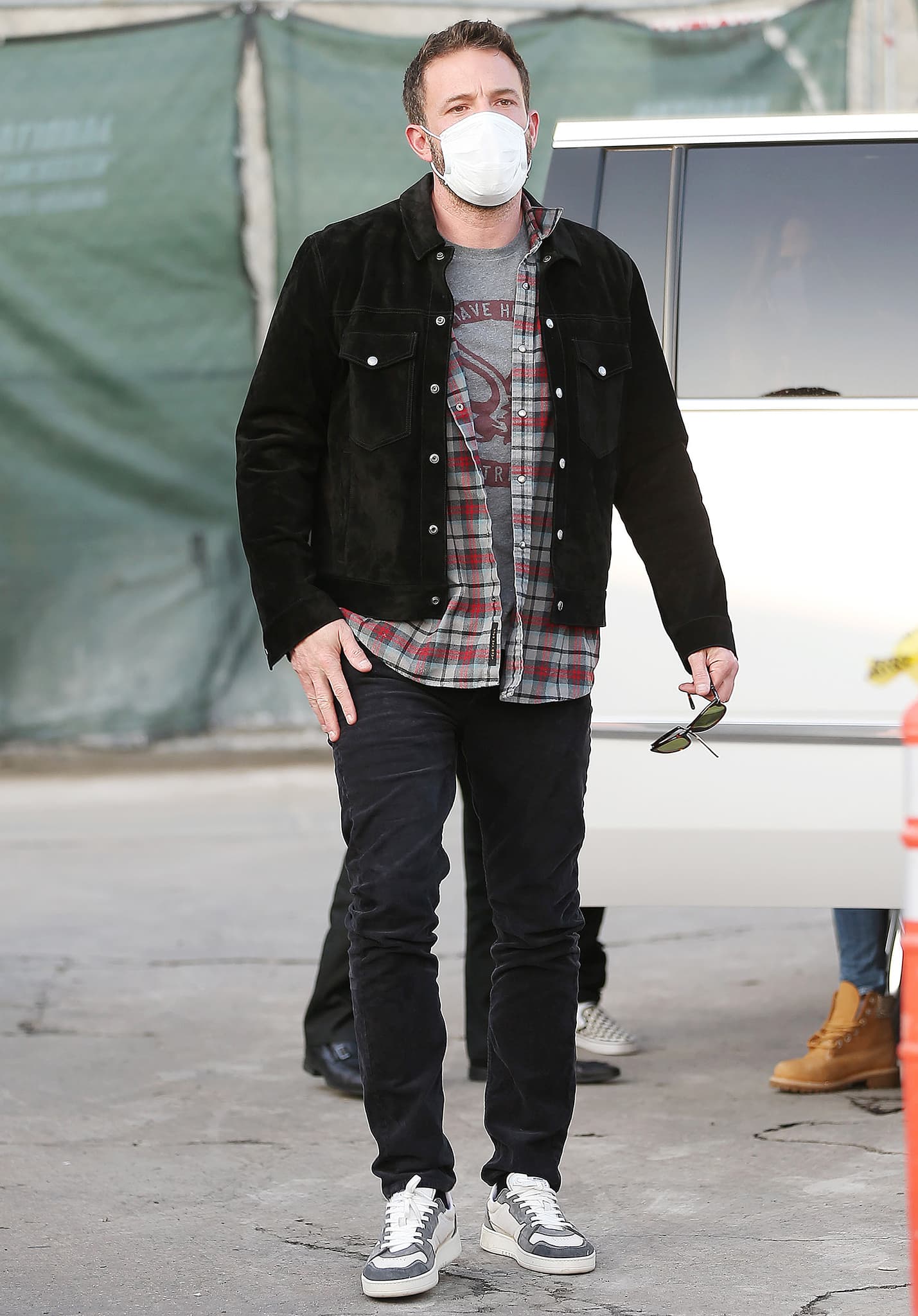 Ben Affleck bundles up in a black jacket, plaid flannel, and a gray tee