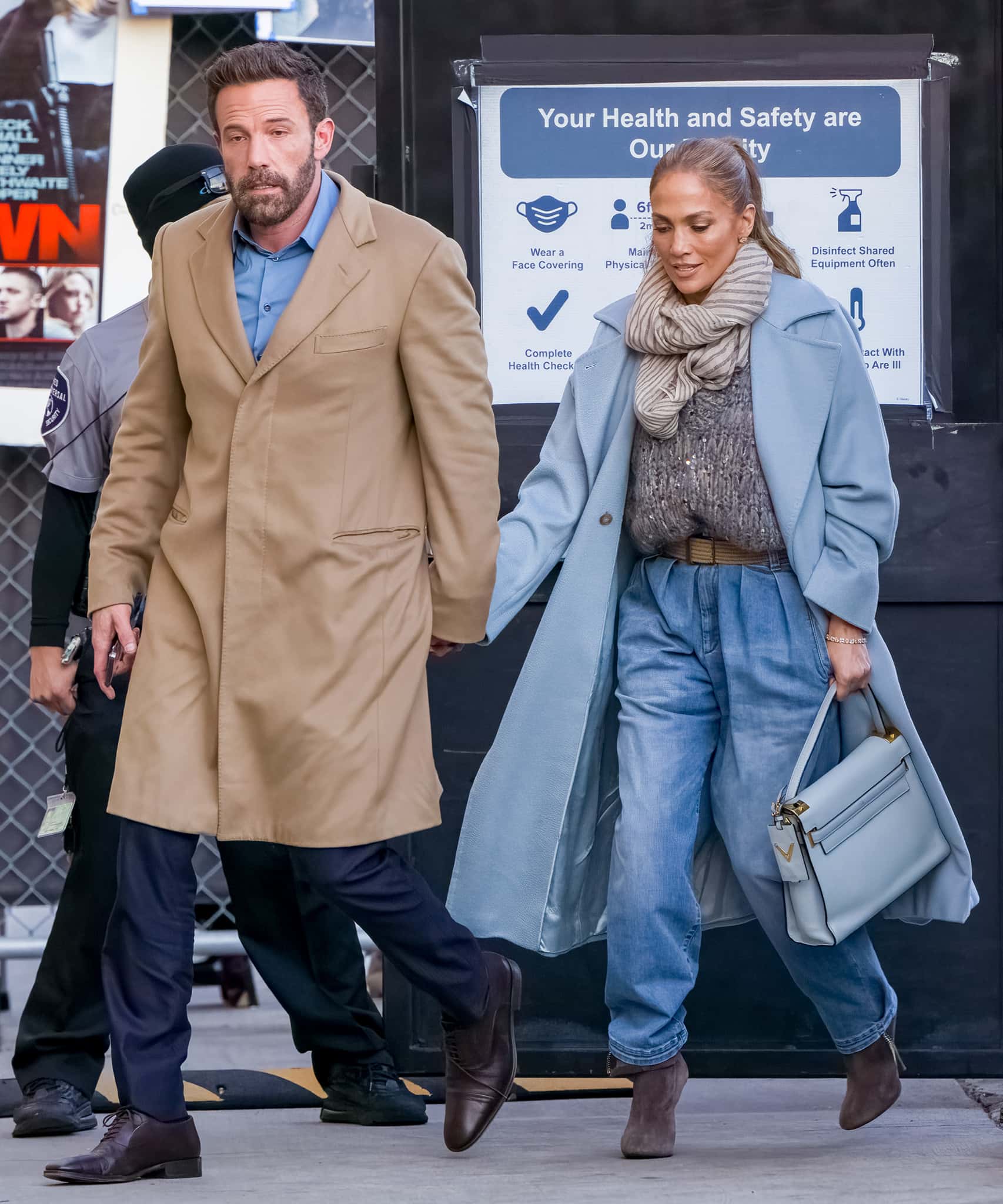 Ben Affleck bundles up in a tan coat while J.Lo keeps warm in a blue coat with a cable-knit sweater, a striped scarf, and a pair of jeans