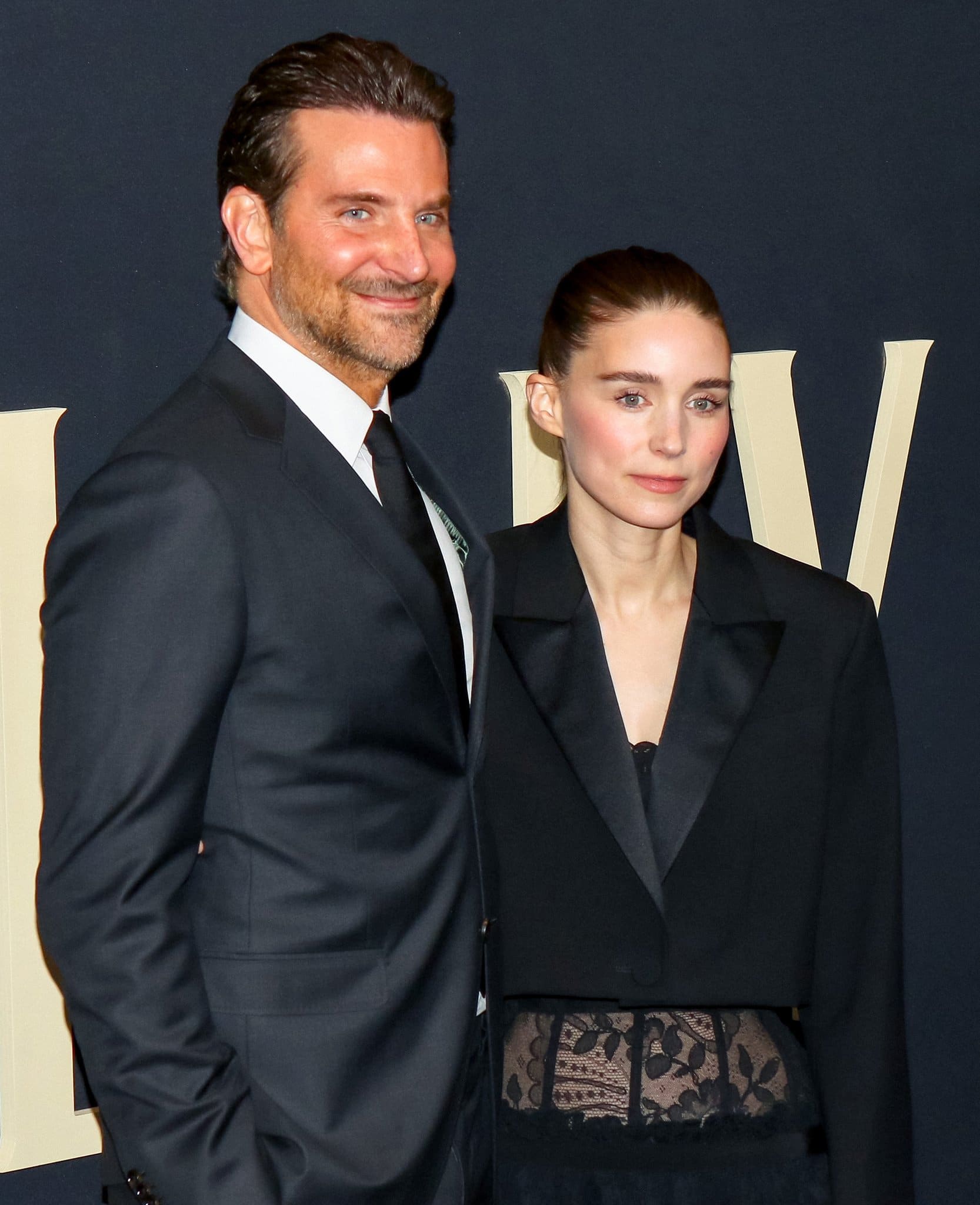 Bradley Cooper looks dashing in a black suit with a white dress shirt and a slim black tie