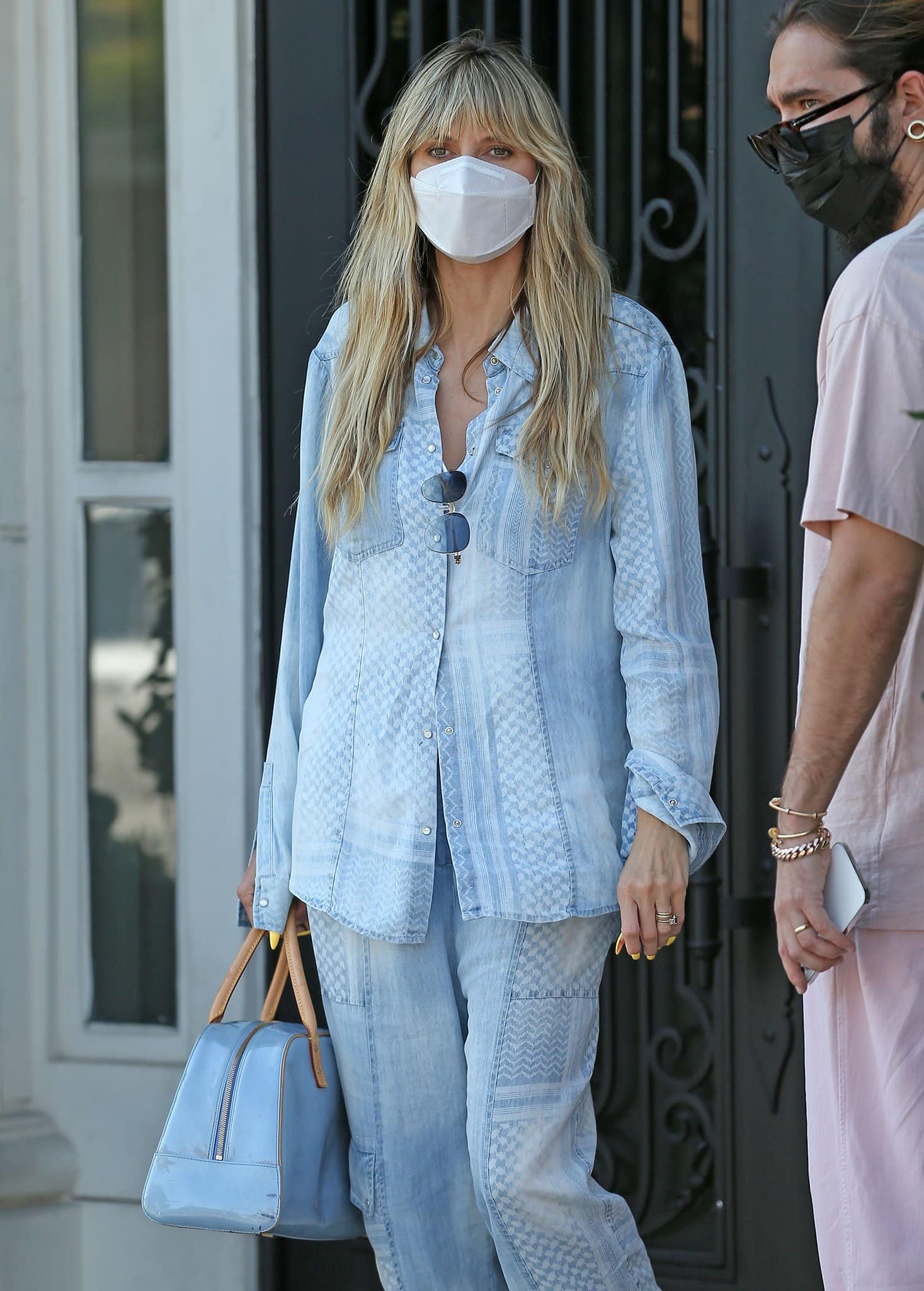 Heidi Klum coordinates her matching denim outfit with her light blue Louis Vuitton Vernis Tompkins bag