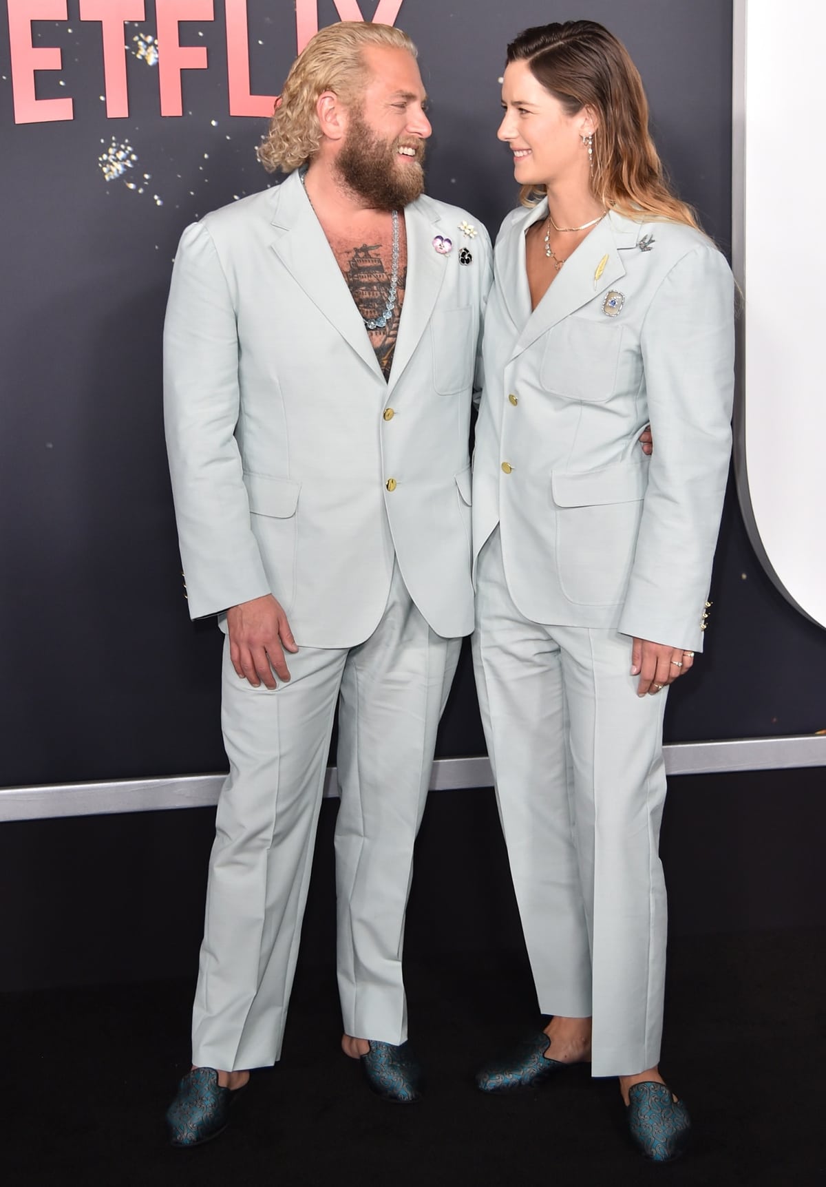 Jonah Hill and Sarah Brady in matching light blue Gucci pantsuits and teal loafers