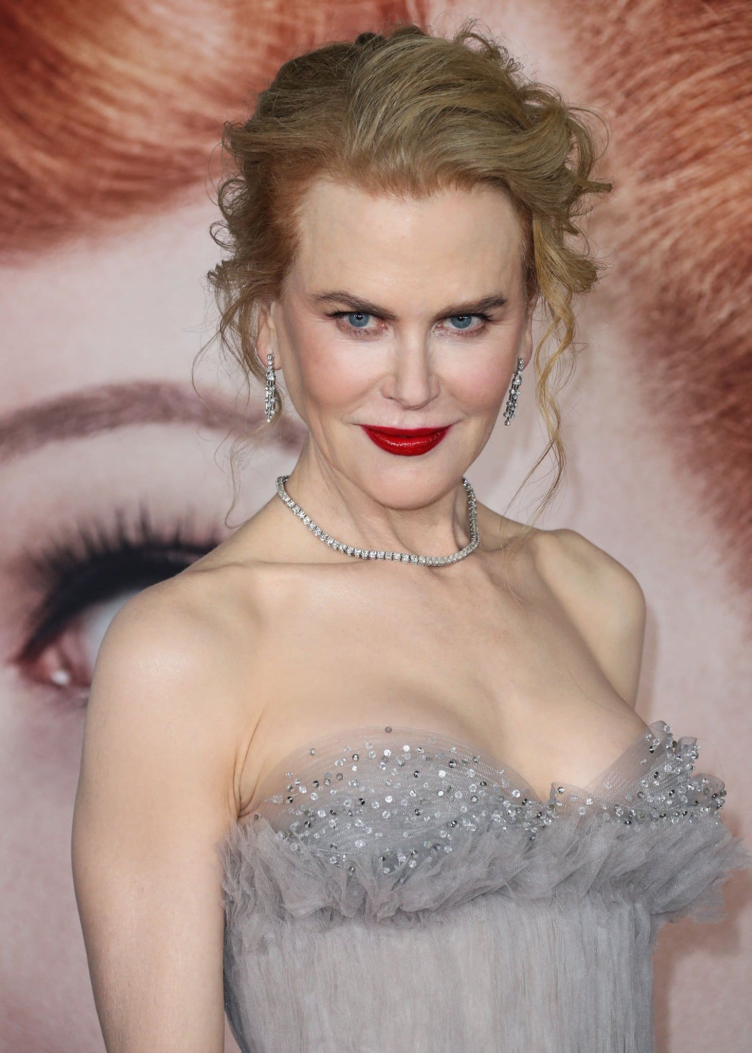 Nicole Kidman continues with the old Hollywood vibe of her look with a wispy updo and a swipe of red lipstick