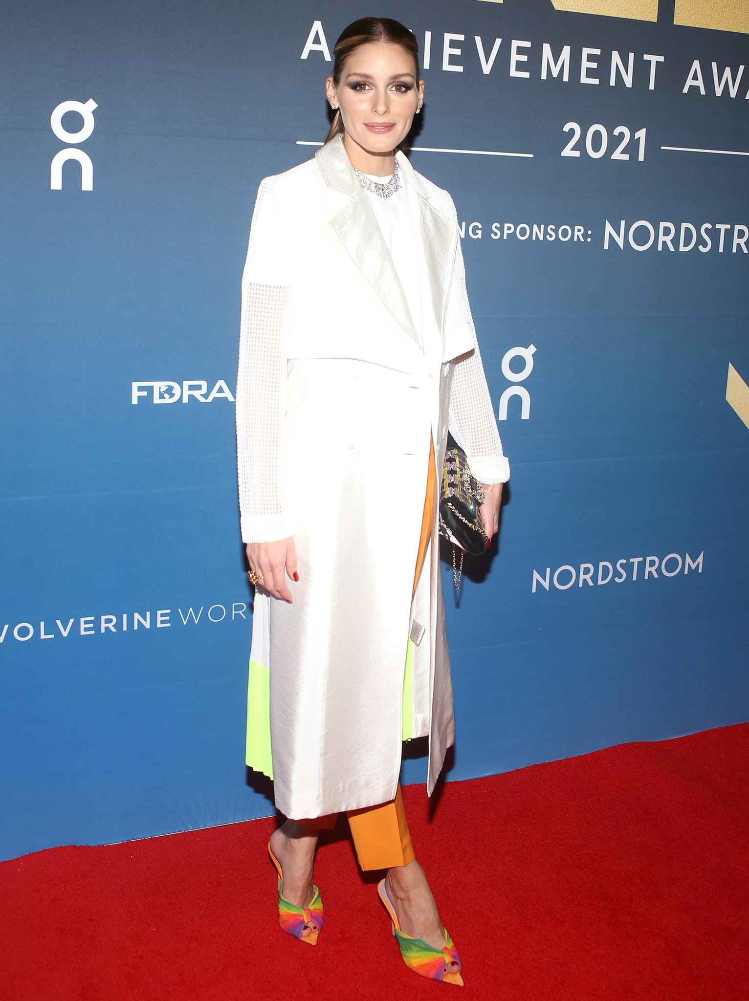 Olivia Palermo dons a chic white Three Floor coat with a white Victoria Beckham tee and marigold trousers