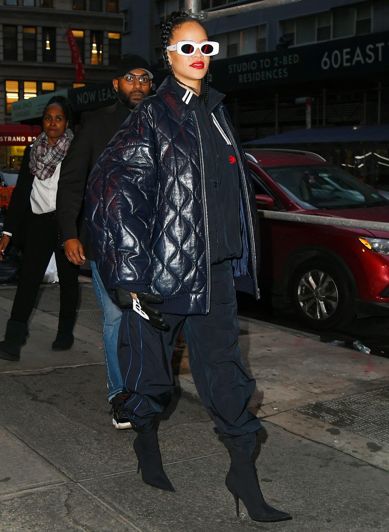 Rihanna effortlessly elevated her street-style look by pairing a quilted Miu Miu jacket and Martine Rose tracksuit with sleek Balenciaga Knife boots and chic white Loewe sunglasses