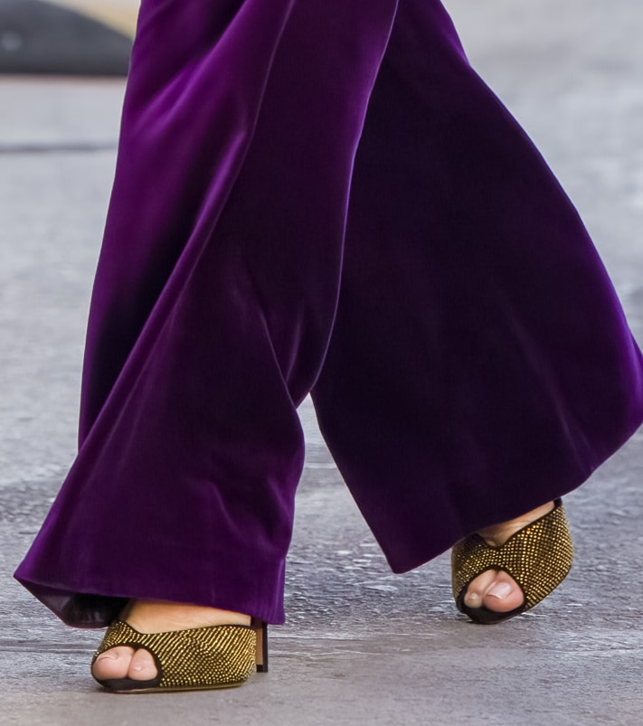 Sandra Bullock adds gold accessories to her purple outfit, finished with Alexandre Birman Jenny sandals