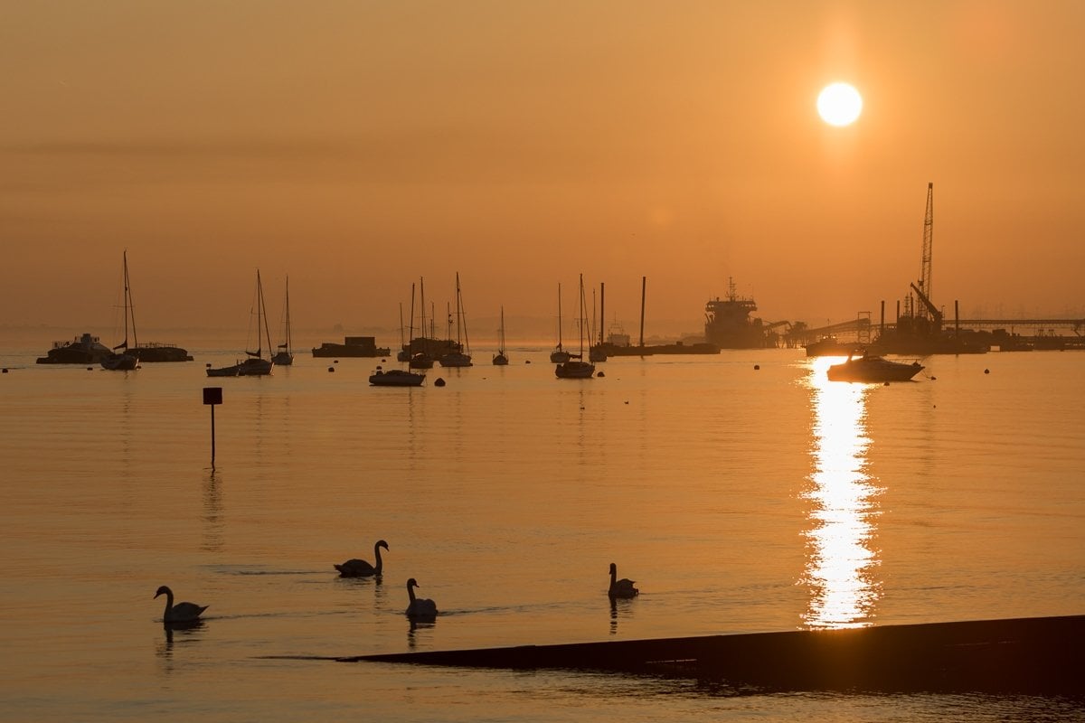 The sun rises above the misty Thames at Gravesend