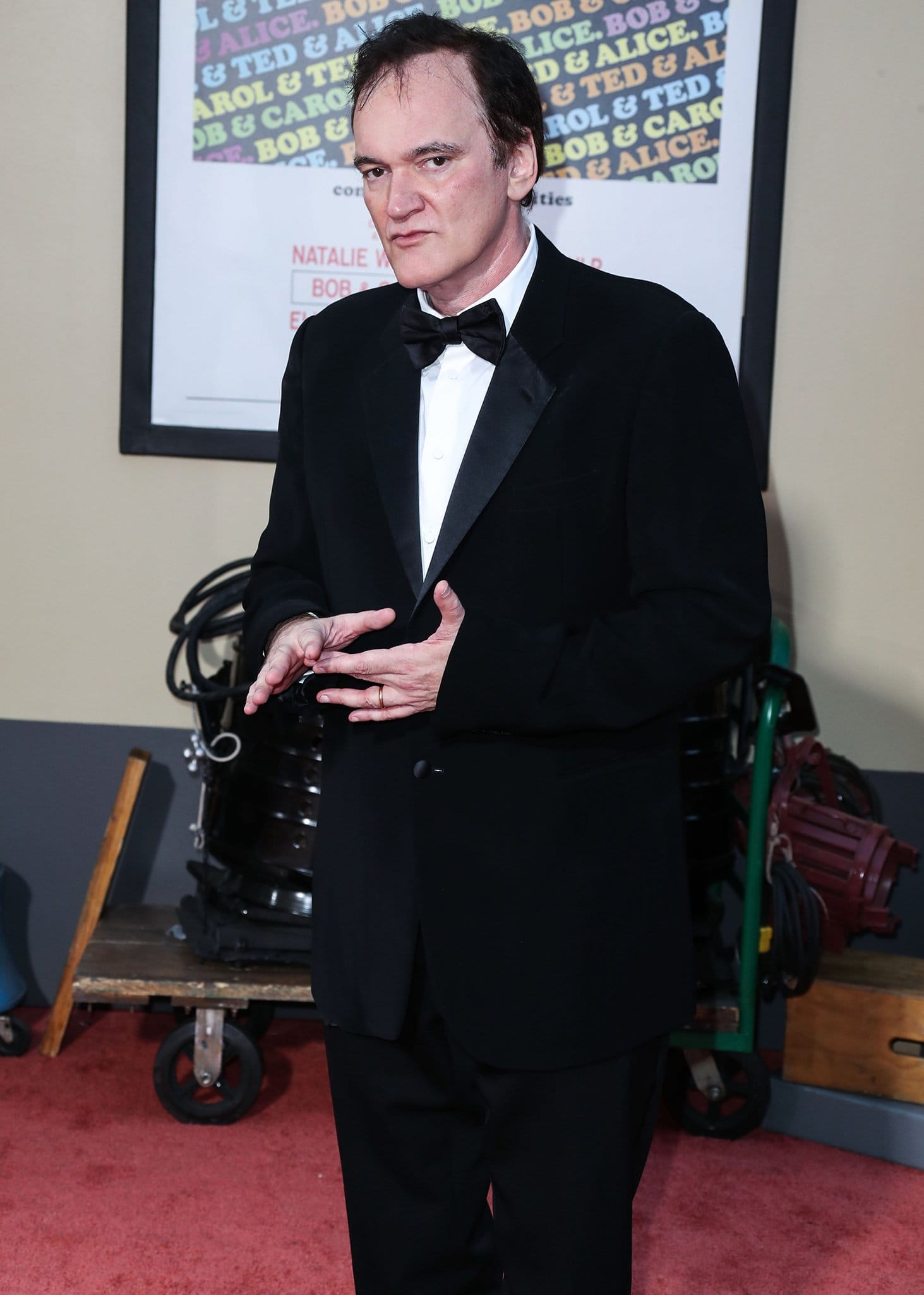 Quentin Tarantino, the legendary director, attends an event in classic black-tie attire, exuding his signature cinematic flair