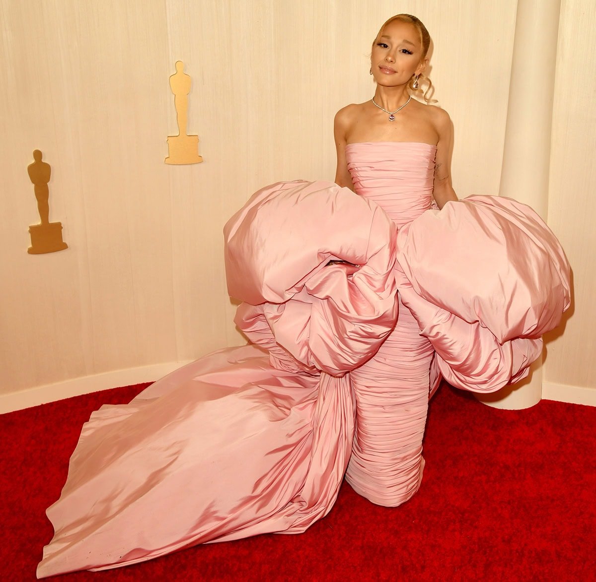 Ariana Grande dazzles in a custom Giambattista Valli pink gown at the 2024 Oscars, channeling her character Glinda with a majestic puff sleeve cape and elegant updo