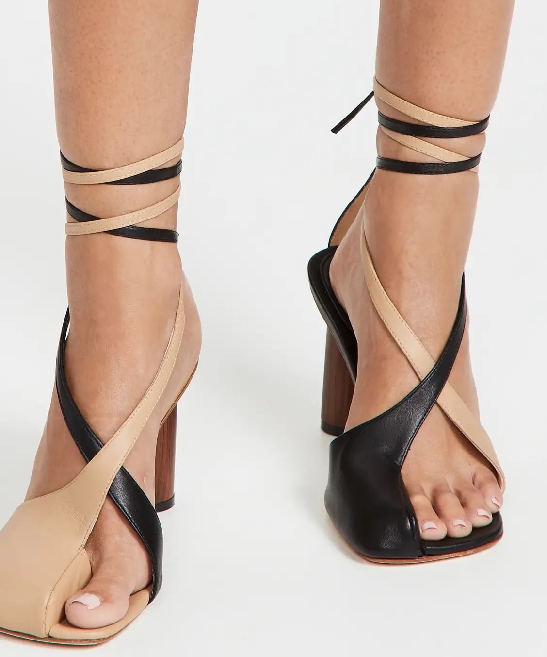 Beige and black asymmetrical open-toe A.W.A.K.E MODE Geraldine wood heel sandals with wraparound ankle tie closure