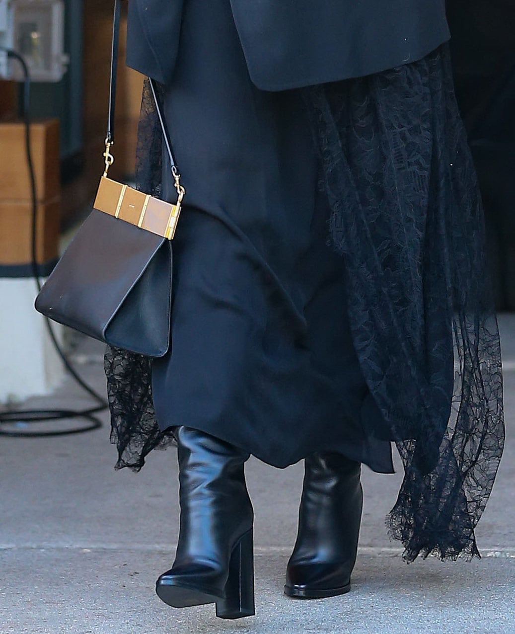 Chrissy Teigen pairs her lace maxi dress with Saint Laurent Cleveland knee-high boots