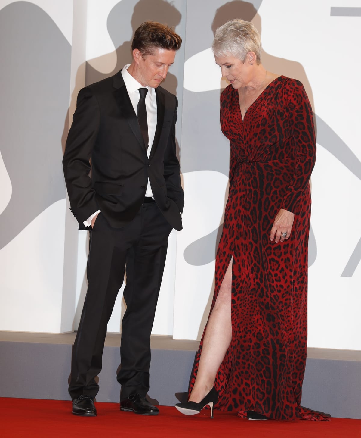 Director David Gordon Green and Jamie Lee Curtis compare shoes on the red carpet of the movie "Halloween Kills"