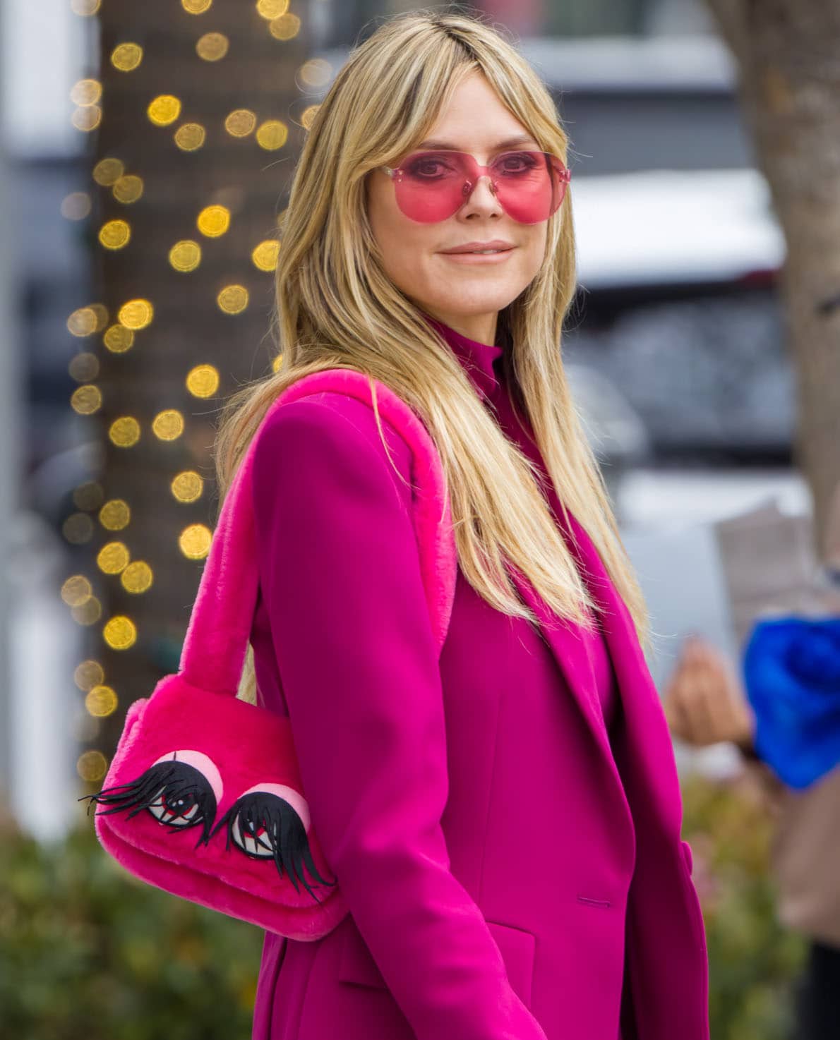 Heidi Klum continues with the hot pink theme of her look by carrying a fuzzy pink Moschino bag with eye decoration