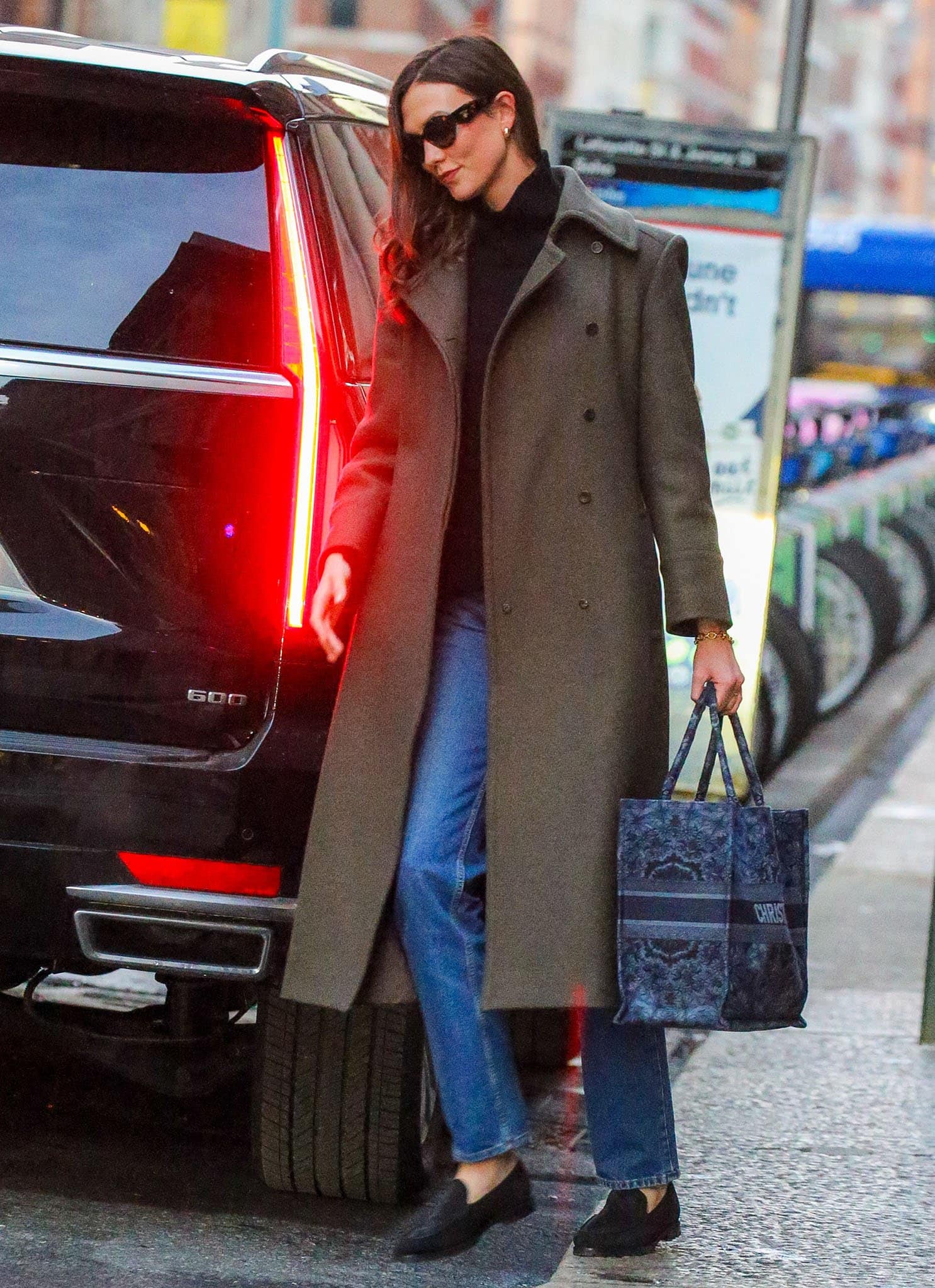Karlie Kloss styles her basic but chic winter outfit with Prada tortoise sunglasses and a Dior Book tote