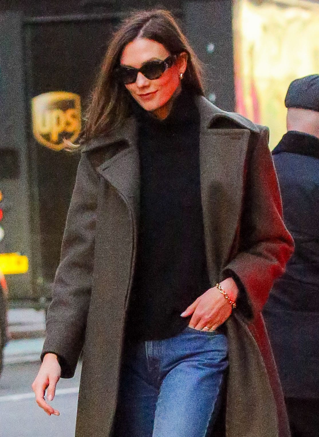 Karlie Kloss bundles up in Alberta Ferretti olive coat, black turtleneck sweater, and straight-leg jeans