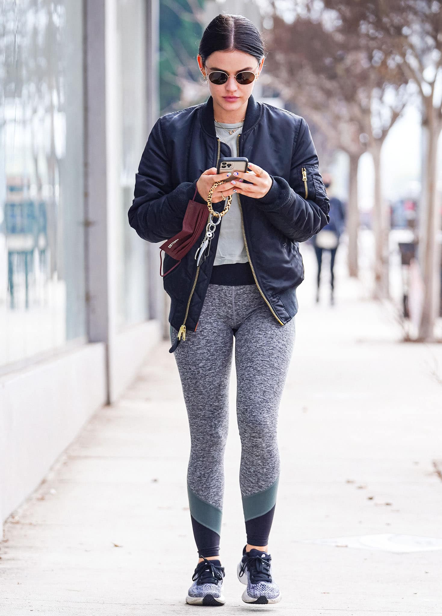Lucy Hale nails athleisure aesthetic in gray tee, leggings, and navy bomber jacket