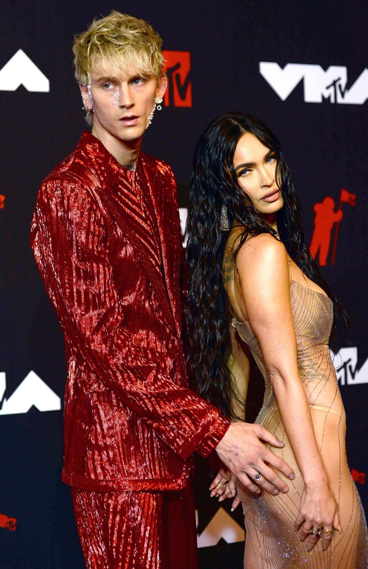 Megan Fox and Machine Gun Kelly push the boundaries of fashion at the MTV VMAs, with Megan in a barely-there sheer dress and MGK in a bold red metallic suit