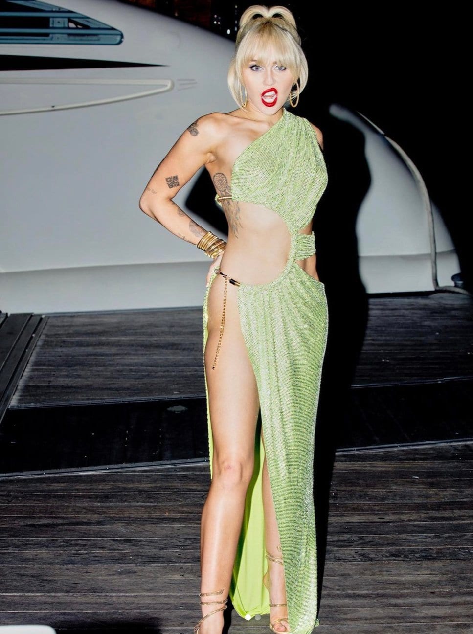 Miley Cyrus flashes her toned abs and legs in Bronx and Banco’s Spring 2022 green dress and Rene Caovilla gold heels