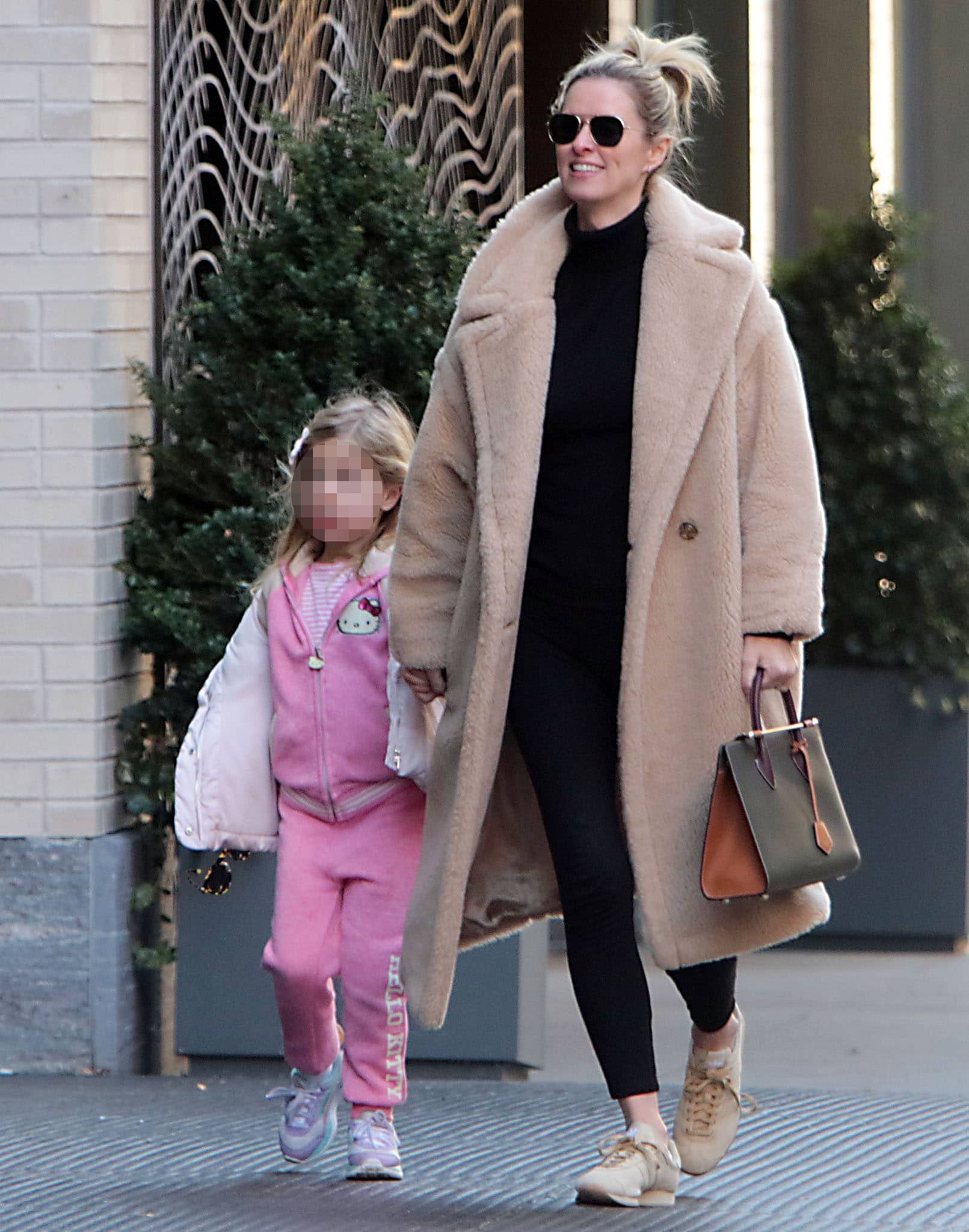 Lily Grace looks cute in her pink Hello Kitty sweatsuit while Nicky Hilton is chic in a Max Mara Teddy coat with a black sweater and leggings