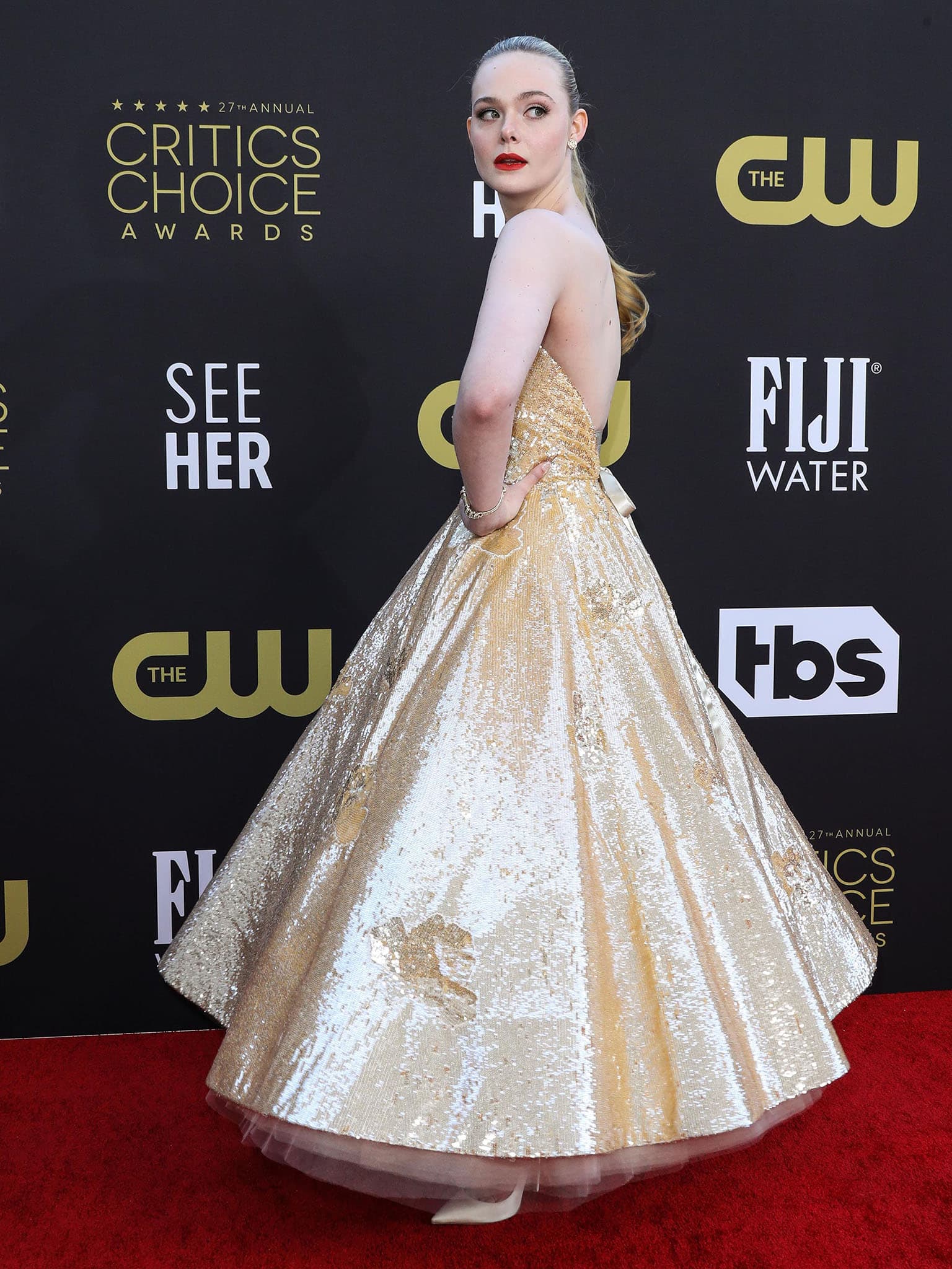 Elle Fanning highlights her arms and tiny waist in a custom Oscar de la Renta gold sequin gown