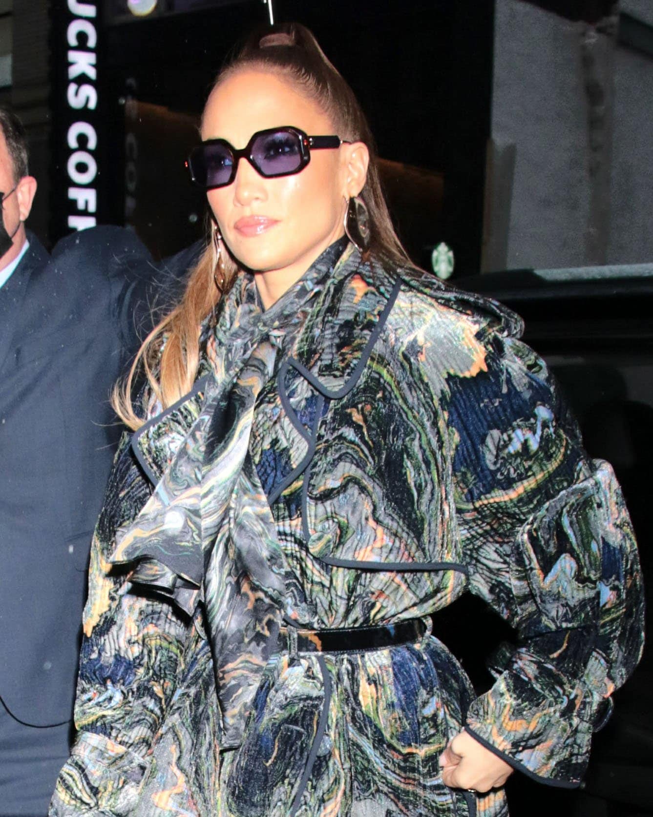 Jennifer Lopez styles her tresses into a high ponytail and accessorizes with Pasquale Bruni earrings and Tory Burch sunglasses