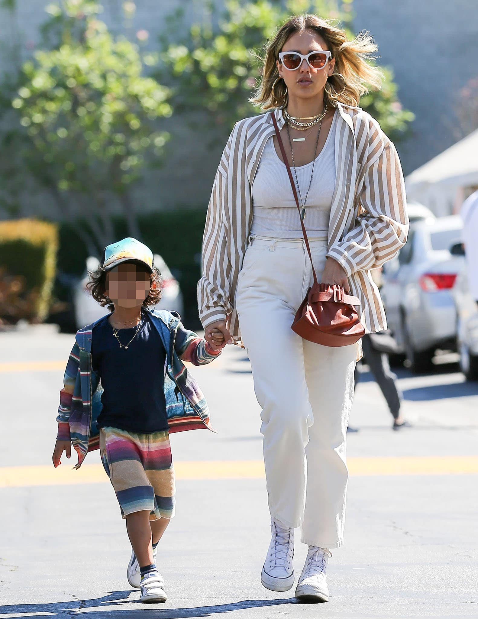 Jessica Alba wears a Kittenish striped shirt with a semi-sheer tank top and cream-colored pants