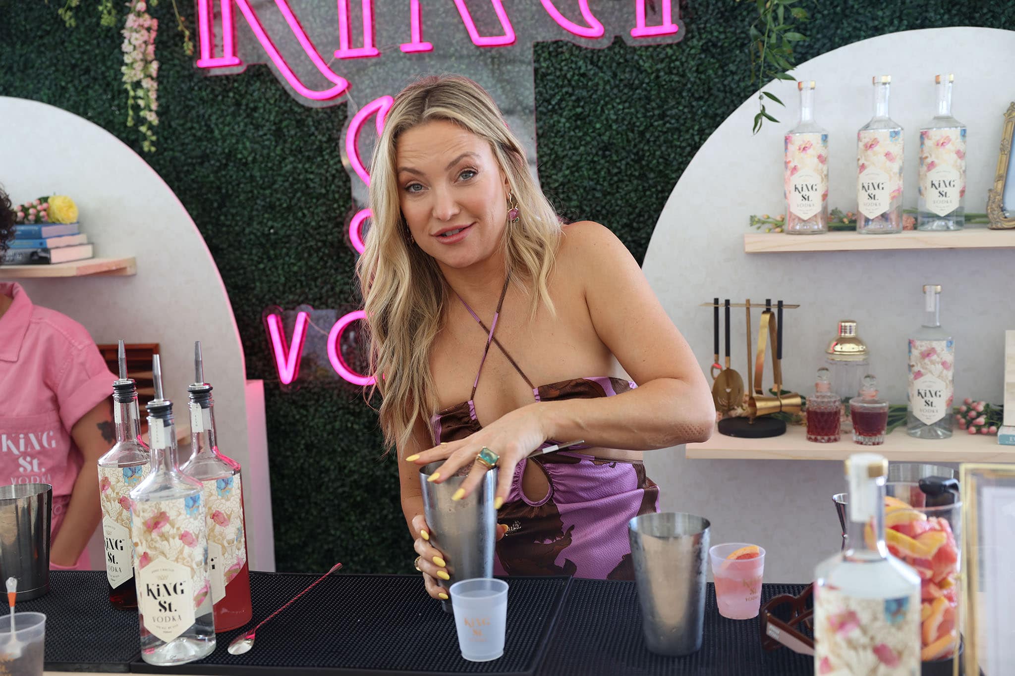 Kate Hudson wears beach waves hair and soft pink makeup with bright yellow nails